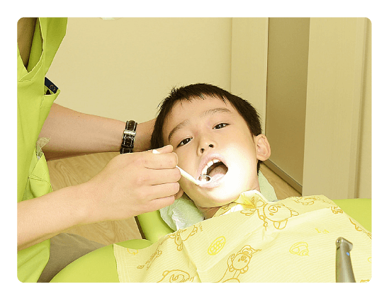 子供が歯の治療を受けている写真